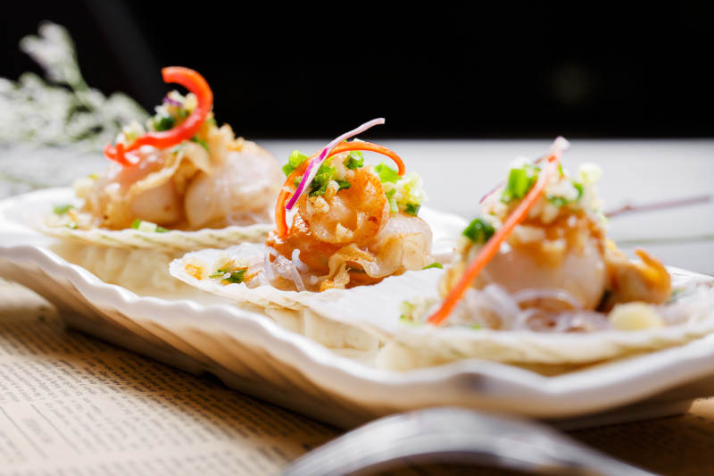 蒜蓉粉丝XO酱蒸扇贝摆放在英文包装纸上图片