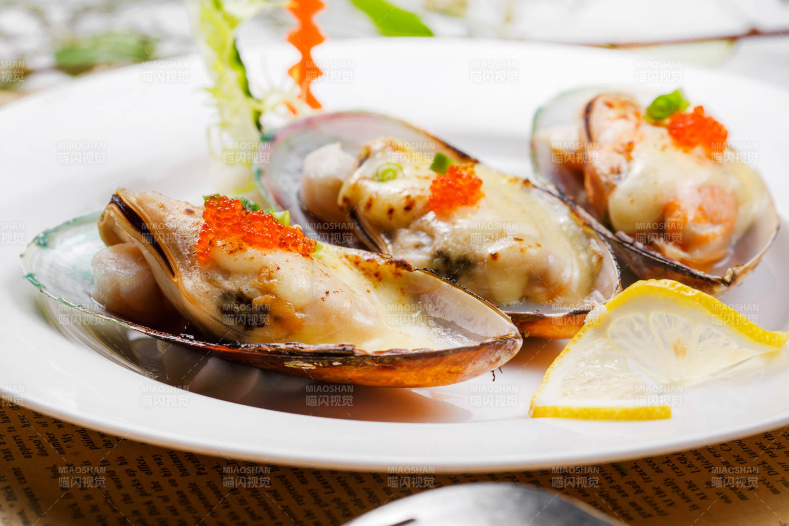 圆形瓷盘装的马苏里拉芝士焗青口贝贻贝摆放在英文包装纸上图片