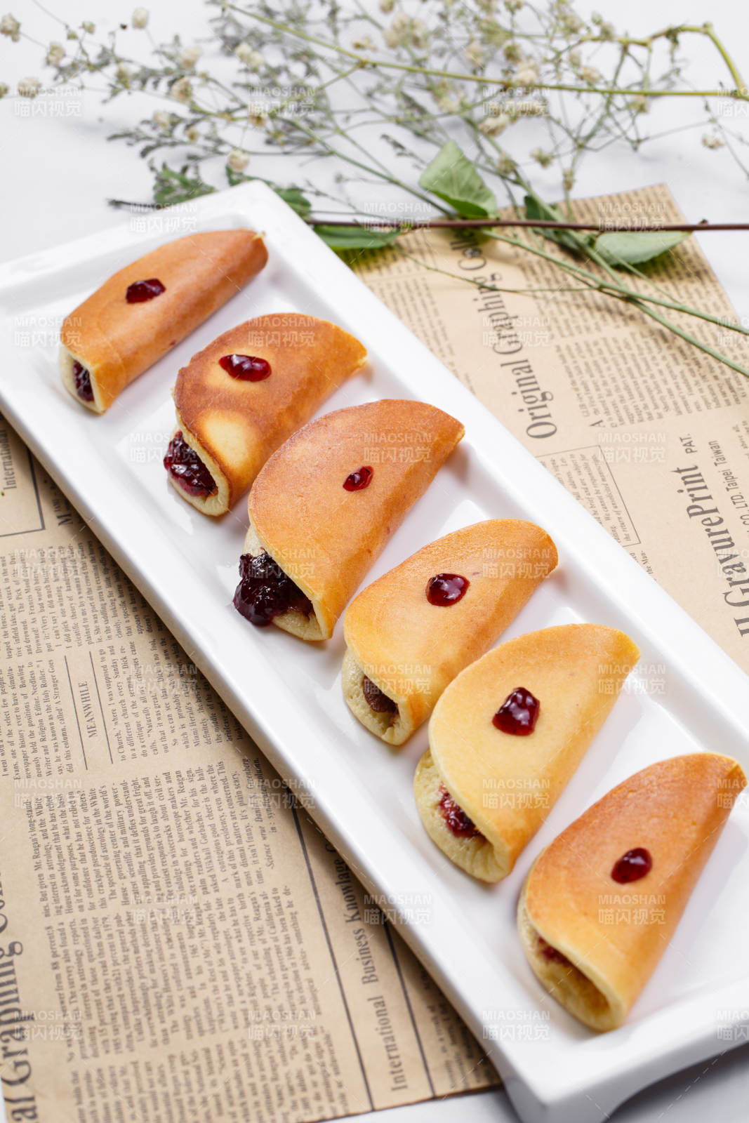 蓝莓夹心派摆放在英文包装纸上图片