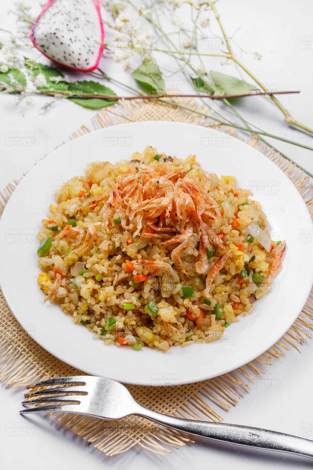 铁板虾干蛋炒饭摆放在草垫上图片