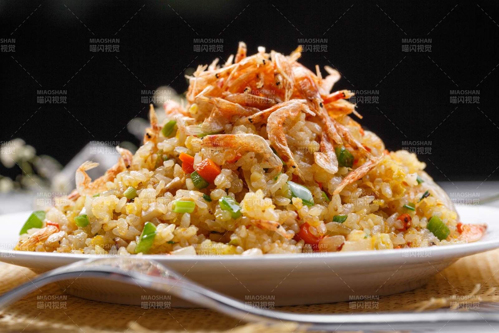 铁板虾干蛋炒饭摆放在草垫上图片