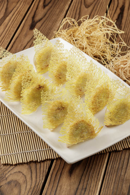 方形白色瓷盘装的渔网煎饺图片