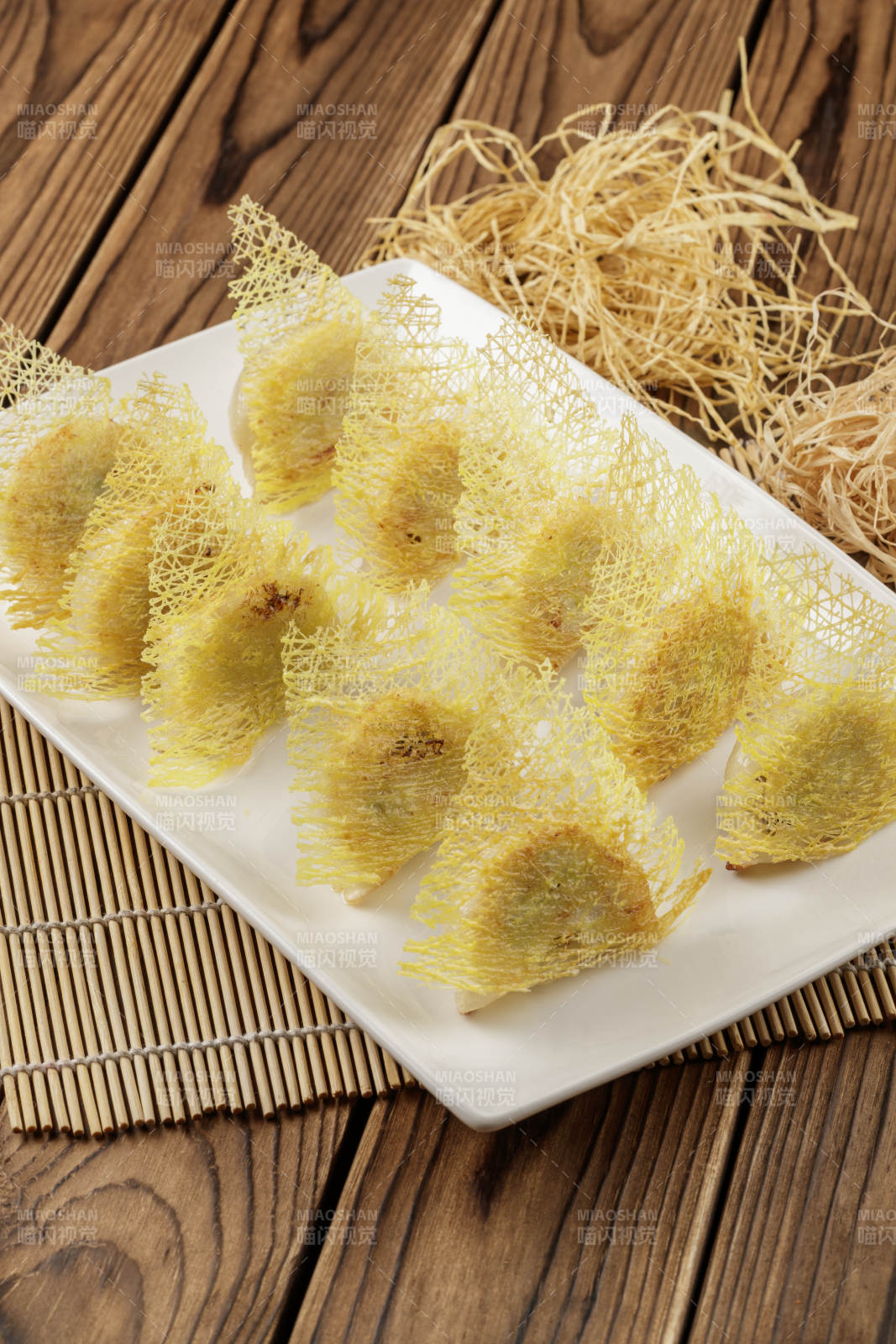 方形白色瓷盘装的渔网煎饺图片