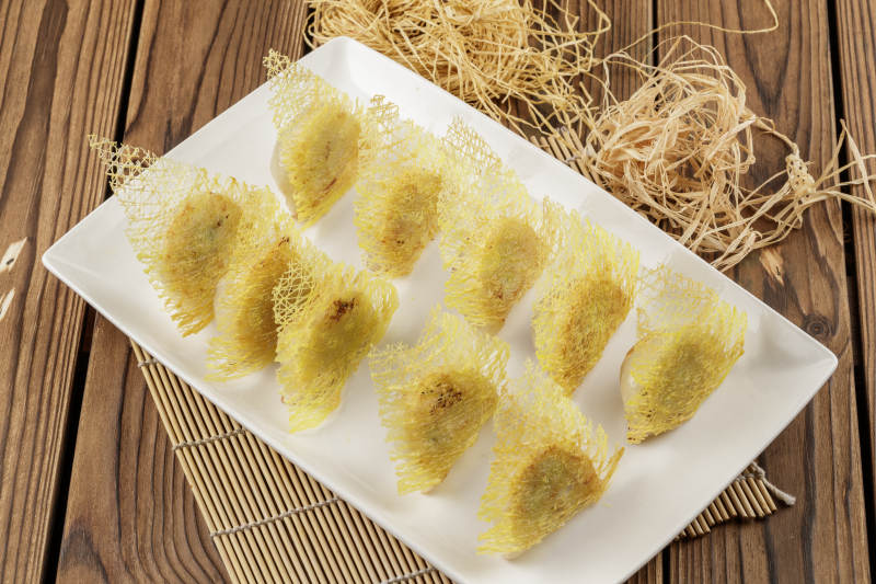 方形白色瓷盘装的渔网煎饺图片