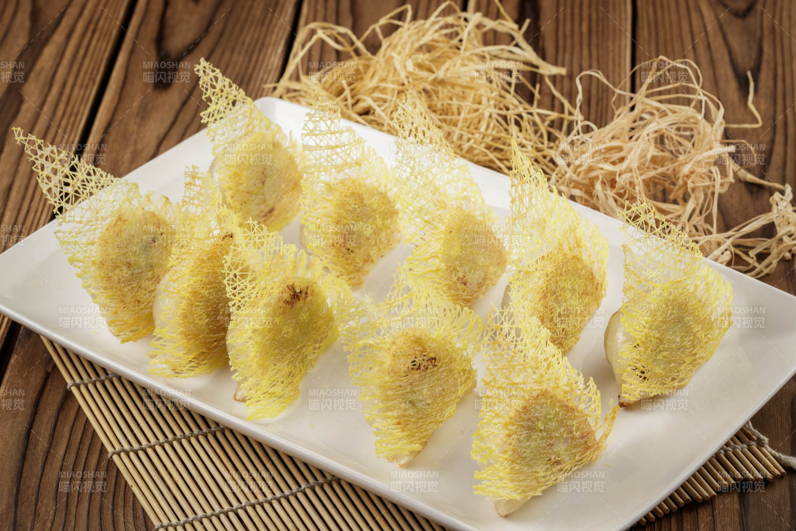 方形白色瓷盘装的渔网煎饺图片