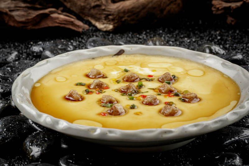 法式鹅肝蒸水蛋摆放在黑色鹅卵石上图片