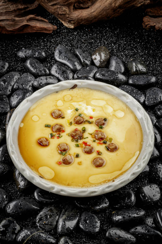 法式鹅肝蒸水蛋摆放在黑色鹅卵石上图片