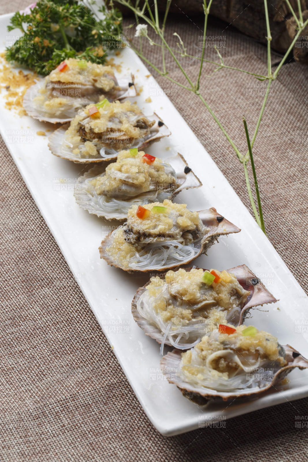 条形长白瓷盘装的蒜蓉粉丝蒸扇贝图片