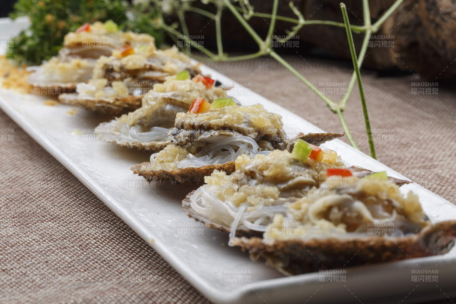 条形长白瓷盘装的蒜蓉粉丝蒸扇贝图片