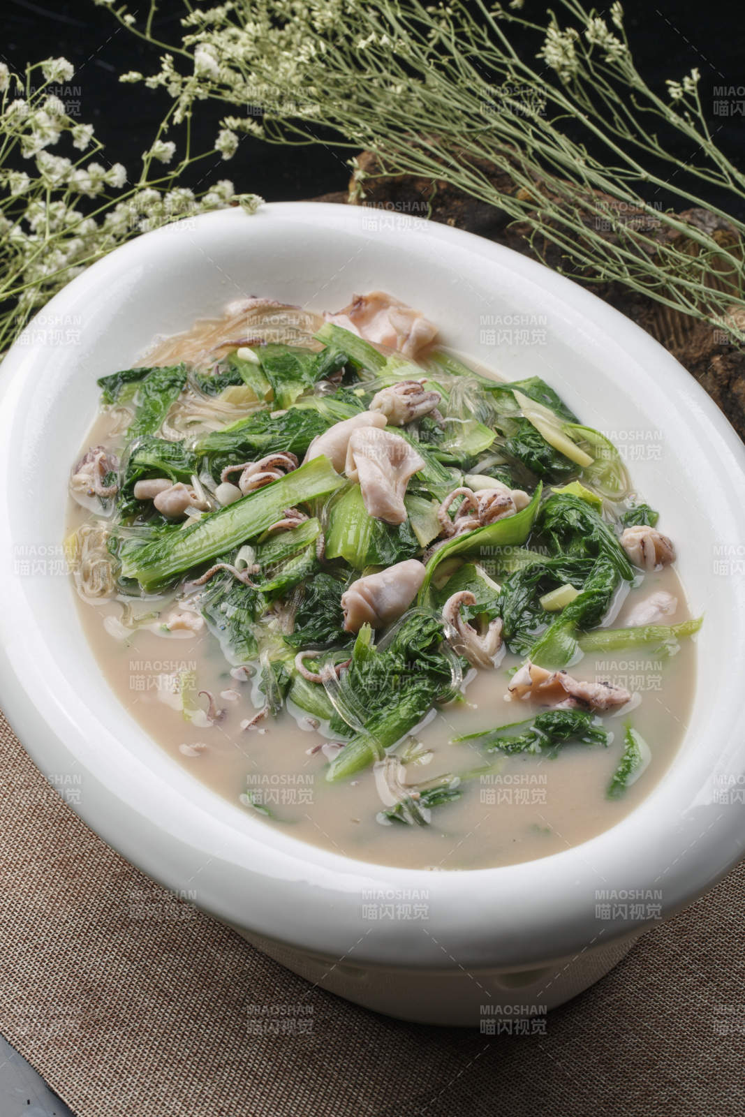 椭圆白瓷盘装的海鲜小白菜烩海兔图片
