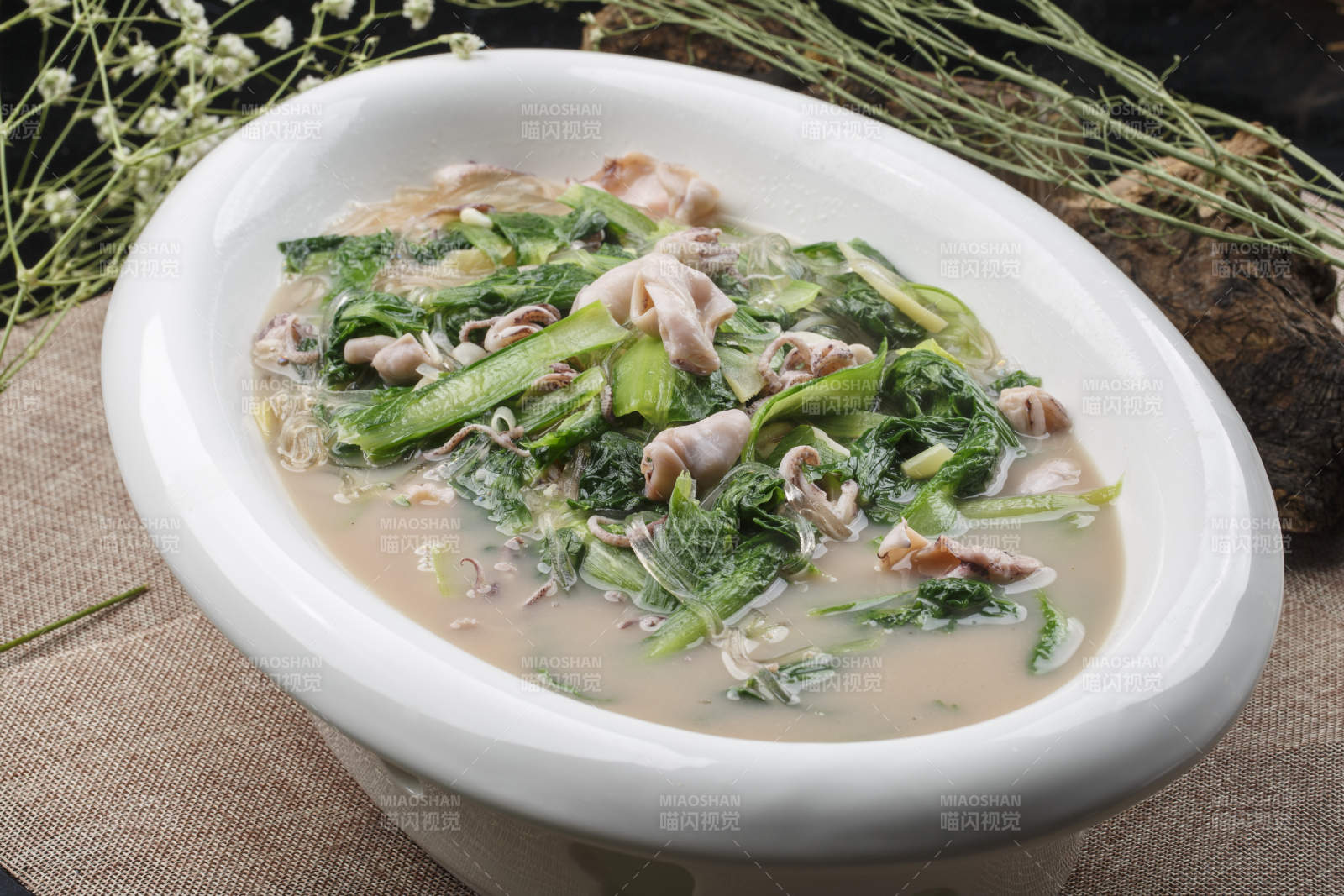 椭圆白瓷盘装的海鲜小白菜烩海兔图片