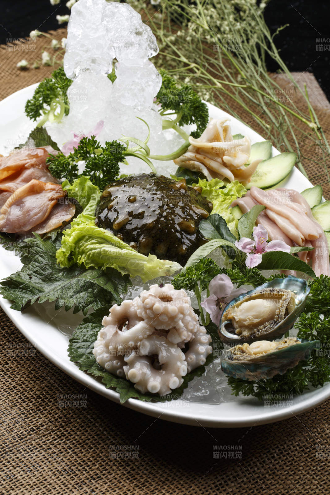 椭圆形白瓷盘装的胶东海鲜刺身拼盘图片