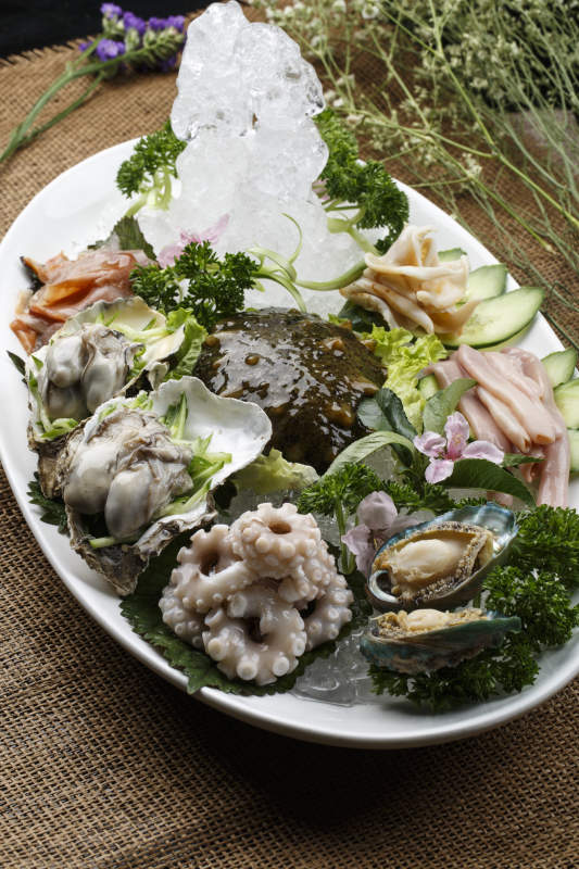 椭圆形白瓷盘装的胶东海鲜刺身拼盘图片