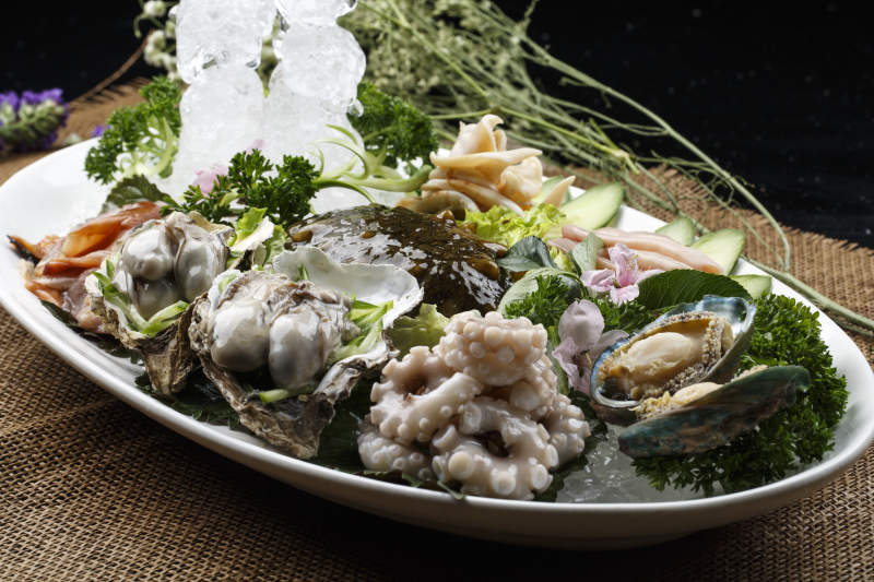 椭圆形白瓷盘装的胶东海鲜刺身拼盘图片