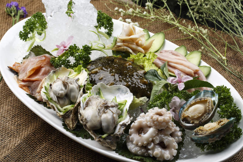 椭圆形白瓷盘装的胶东海鲜刺身拼盘图片