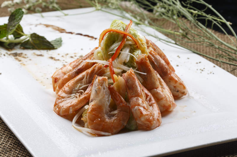 方形白瓷盘装的大明虾炒菜心图片