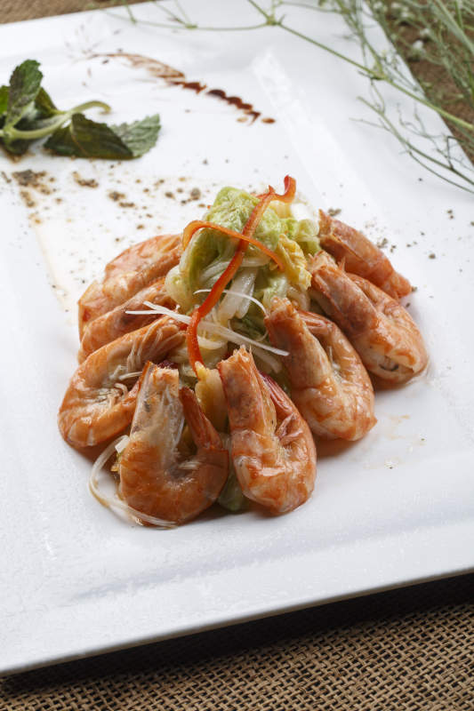 方形白瓷盘装的大明虾炒菜心图片