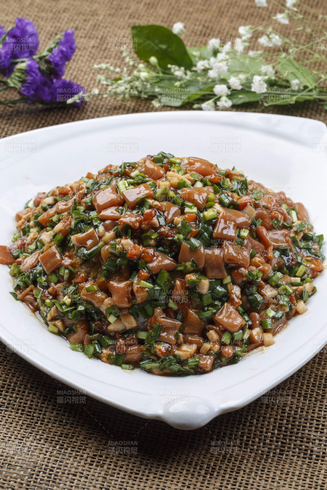 三角形白瓷盘装的海鲜韭菜炒海肠图片