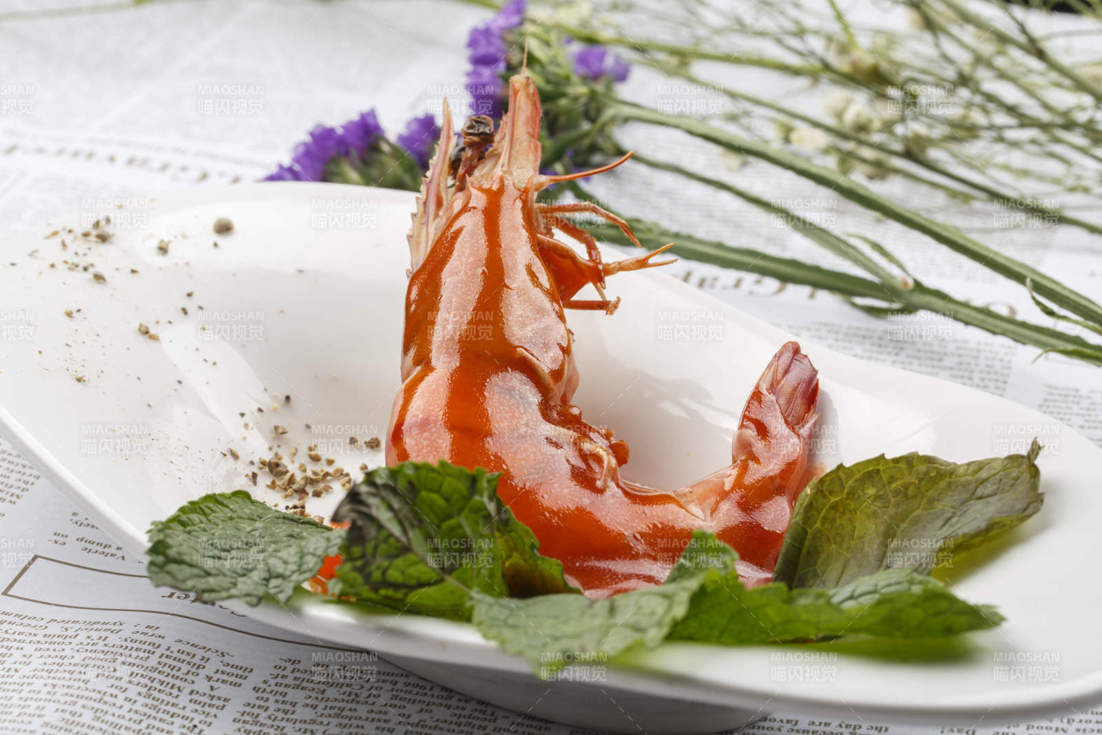 白色椭圆瓷盘装的浇汁大明虾图片