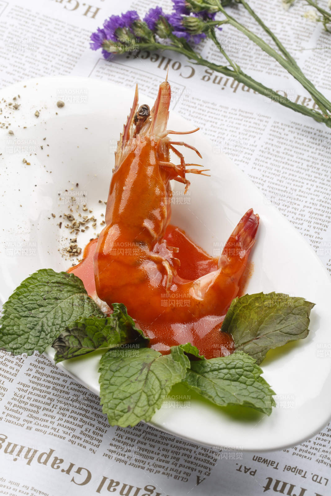 白色椭圆瓷盘装的浇汁大明虾图片