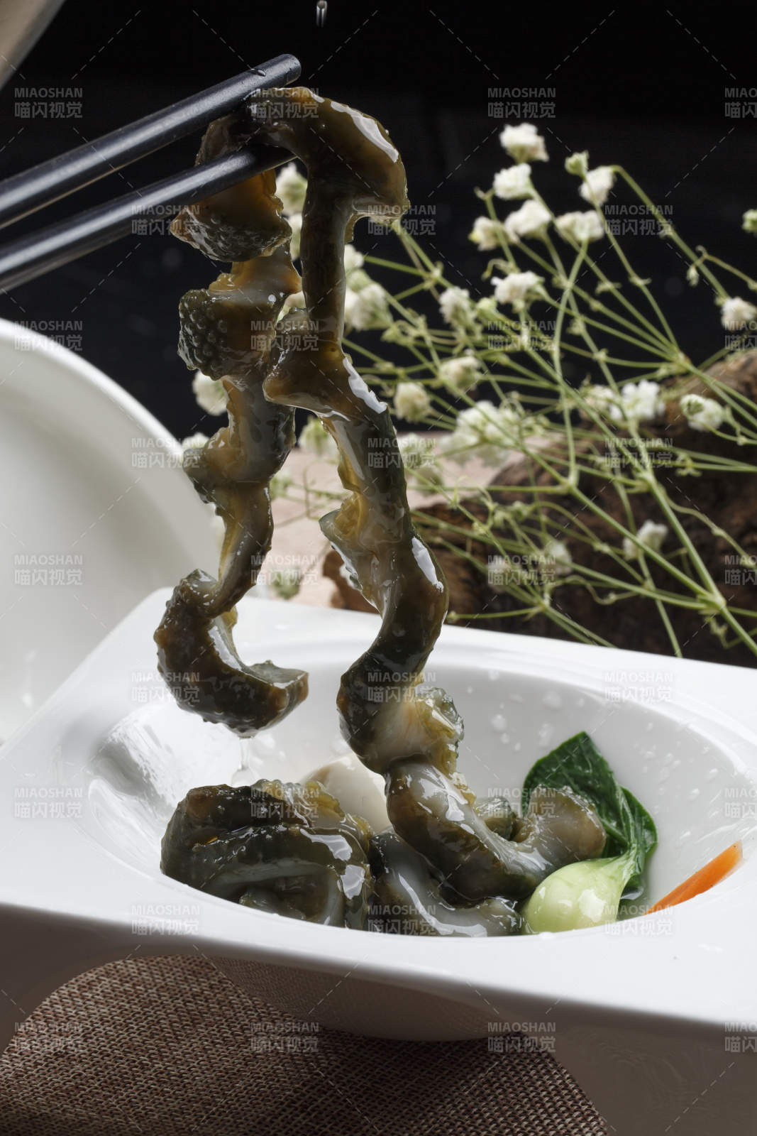 白色方形瓷盘装的海鲜冲浪活海参海参刺身图片