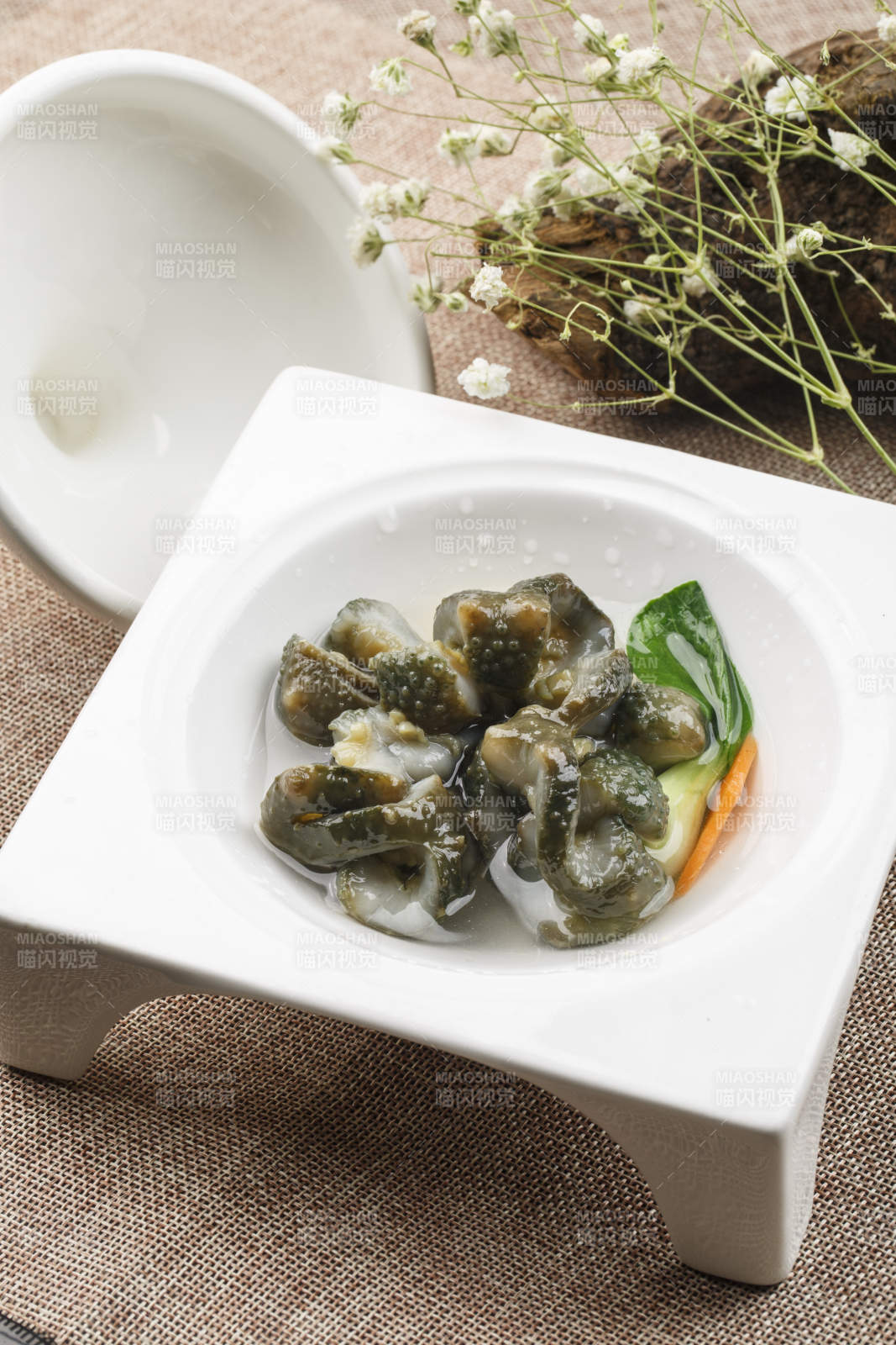 白色方形瓷盘装的海鲜冲浪活海参海参刺身图片