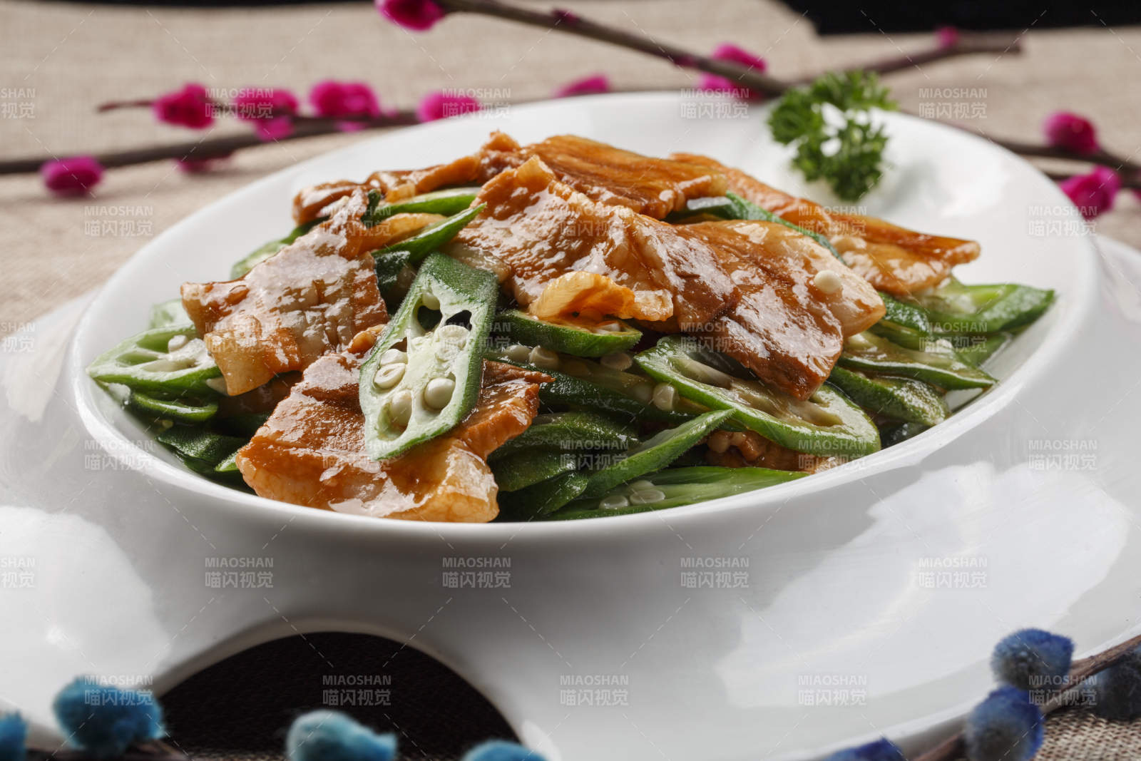 白色瓷餐具装的鲜秋葵炒五花肉图片