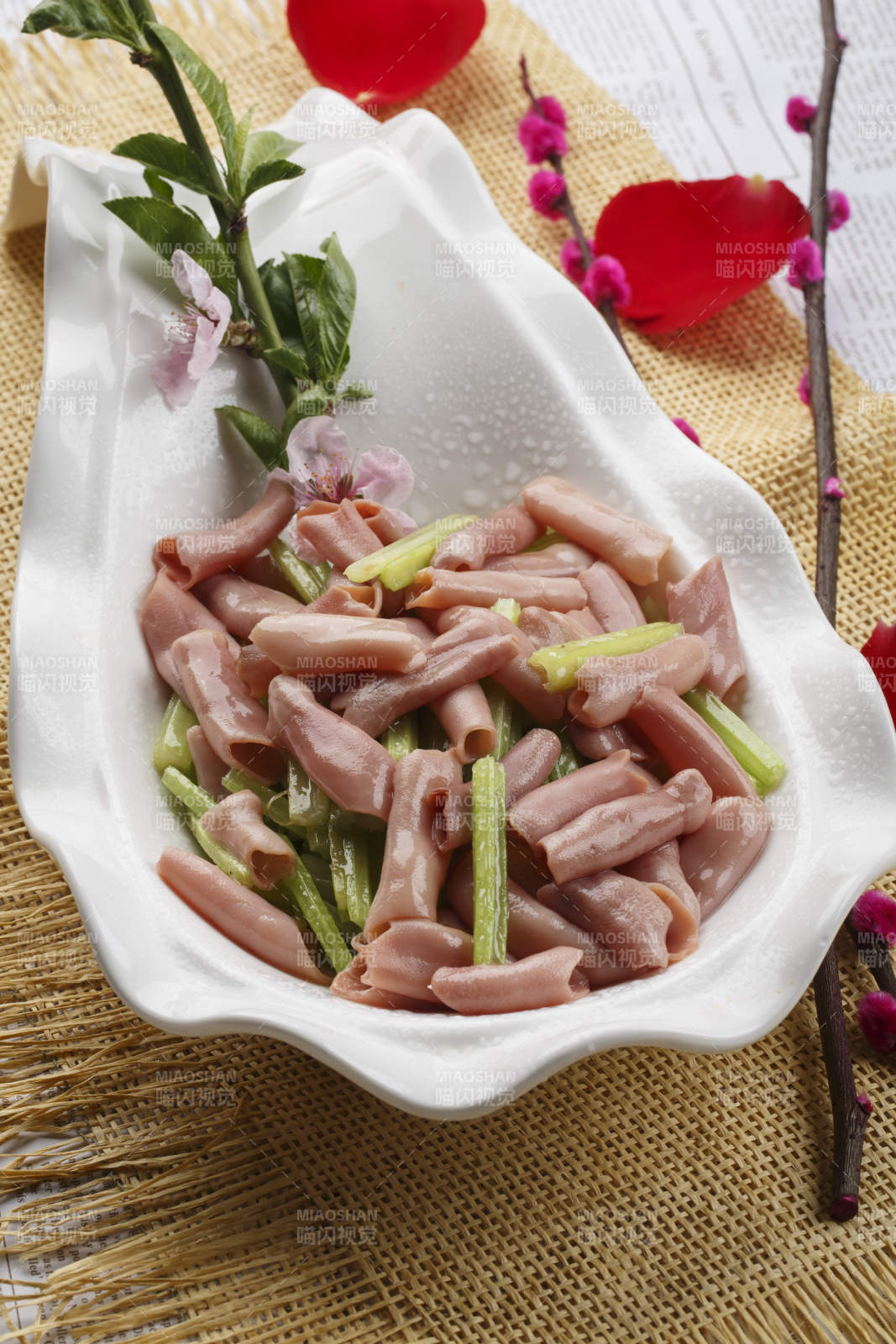 浪花边白色瓷盘装的海鲜清香海肠图片