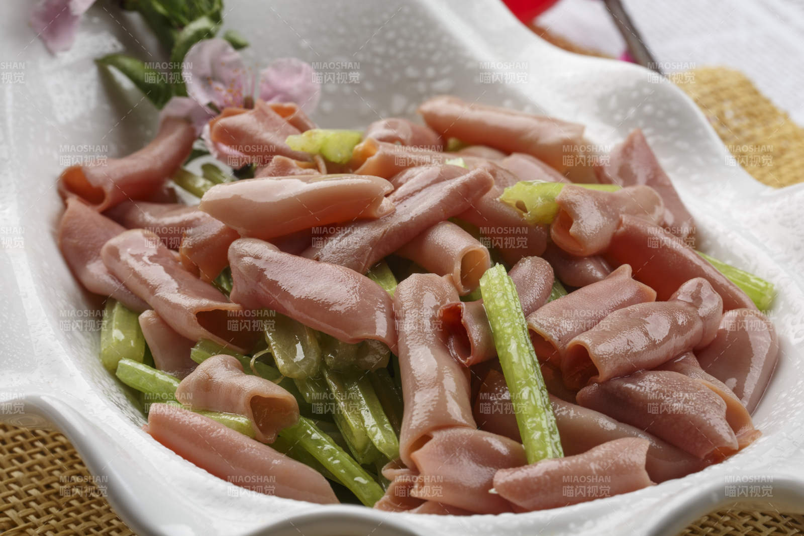 浪花边白色瓷盘装的海鲜清香海肠图片