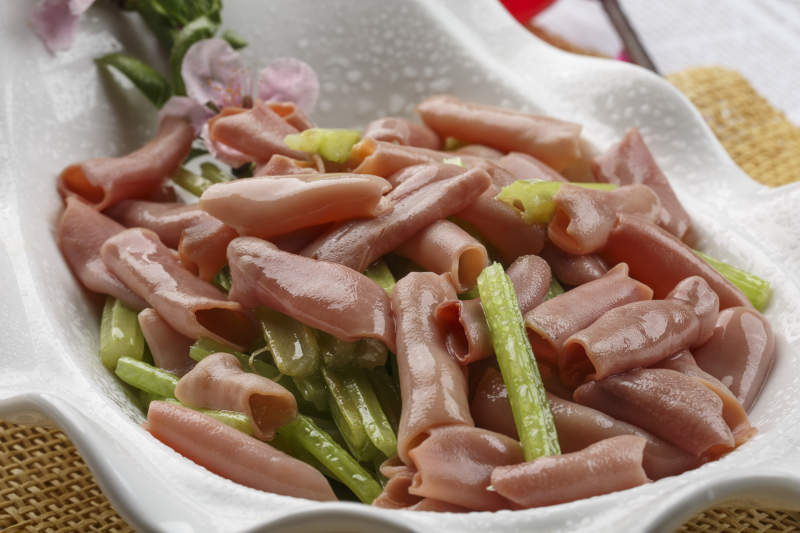 浪花边白色瓷盘装的海鲜清香海肠图片