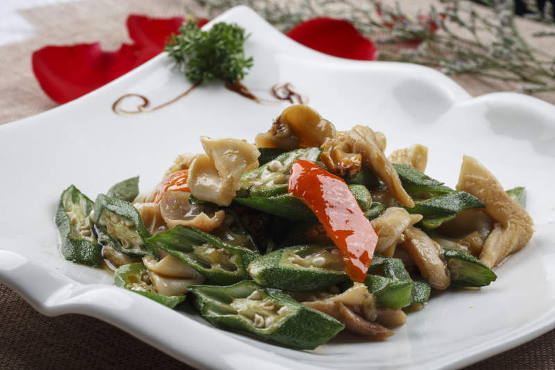 方形浪花边白瓷盘装的海鲜秋葵炒大海螺肉图片