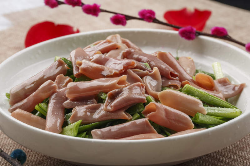 圆形白瓷盘装的海鲜韭菜炒海肠图片