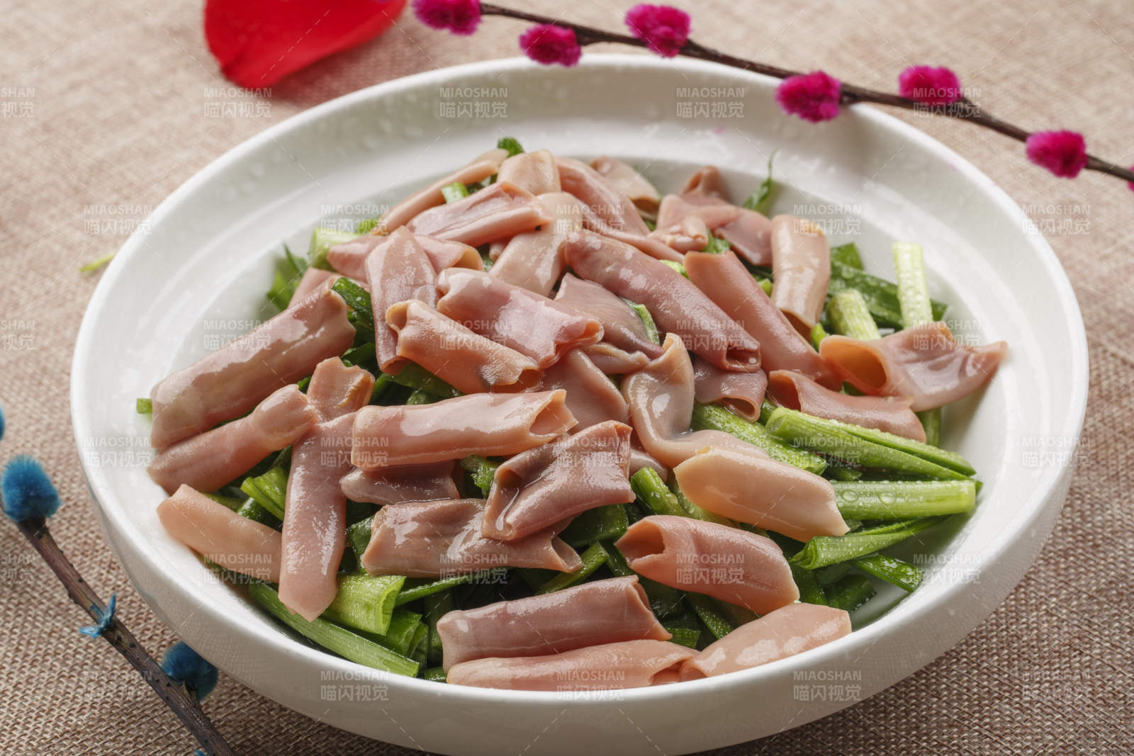 圆形白瓷盘装的海鲜韭菜炒海肠图片