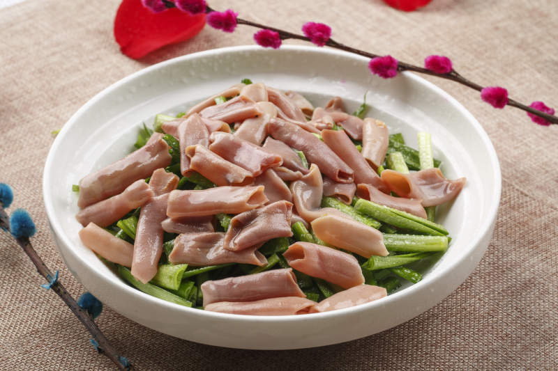 圆形白瓷盘装的海鲜韭菜炒海肠图片