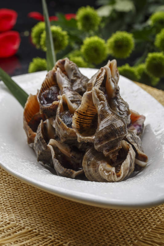 异形白瓷盘装的海鲜酱爆小海螺图片