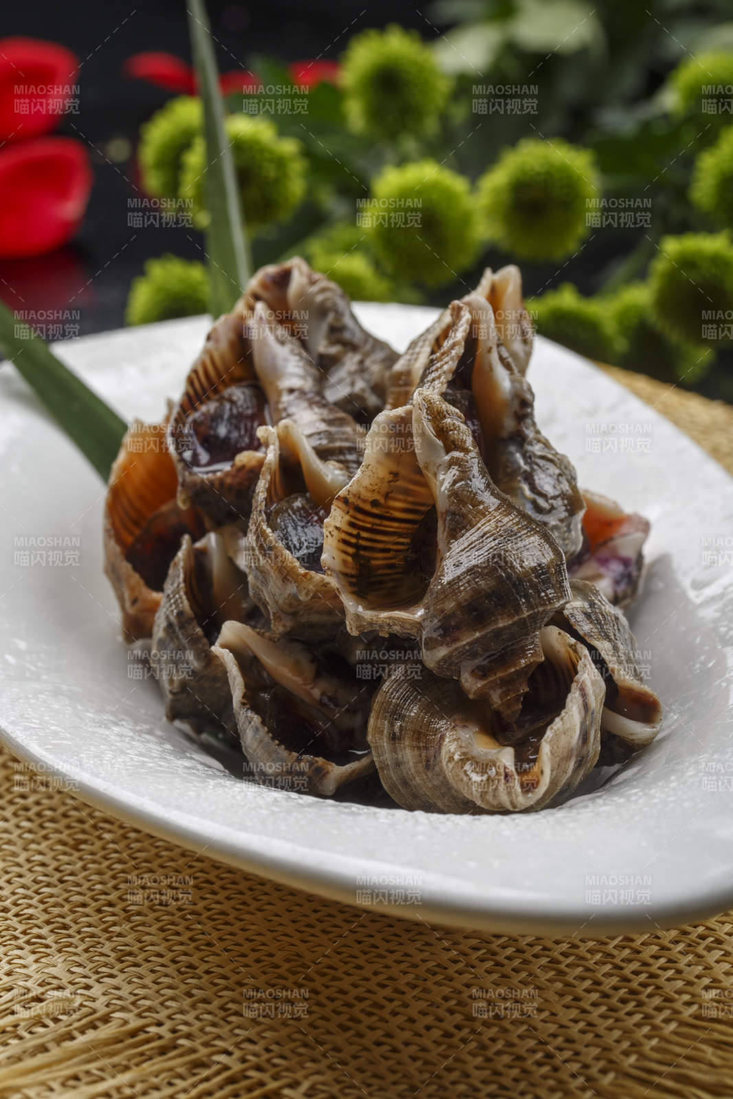 异形白瓷盘装的海鲜酱爆小海螺图片