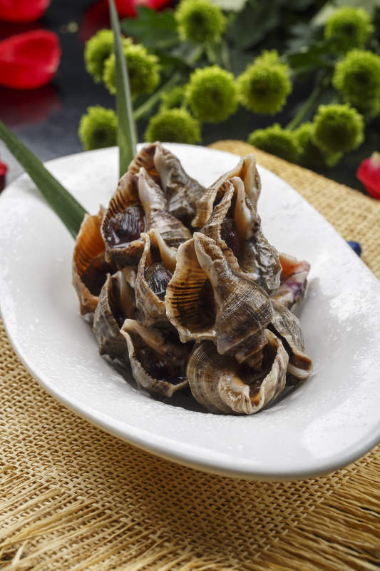 异形白瓷盘装的海鲜酱爆小海螺图片