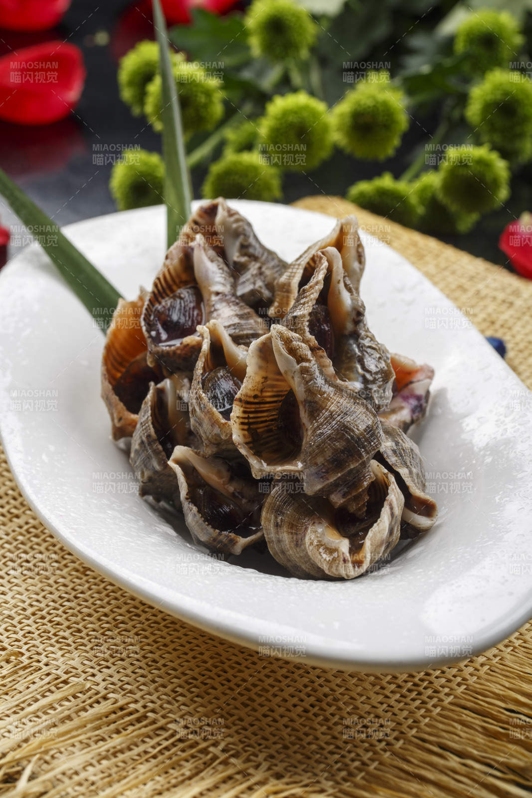 异形白瓷盘装的海鲜酱爆小海螺图片
