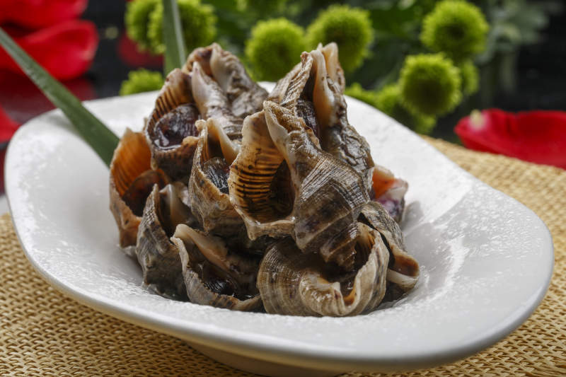 异形白瓷盘装的海鲜酱爆小海螺图片