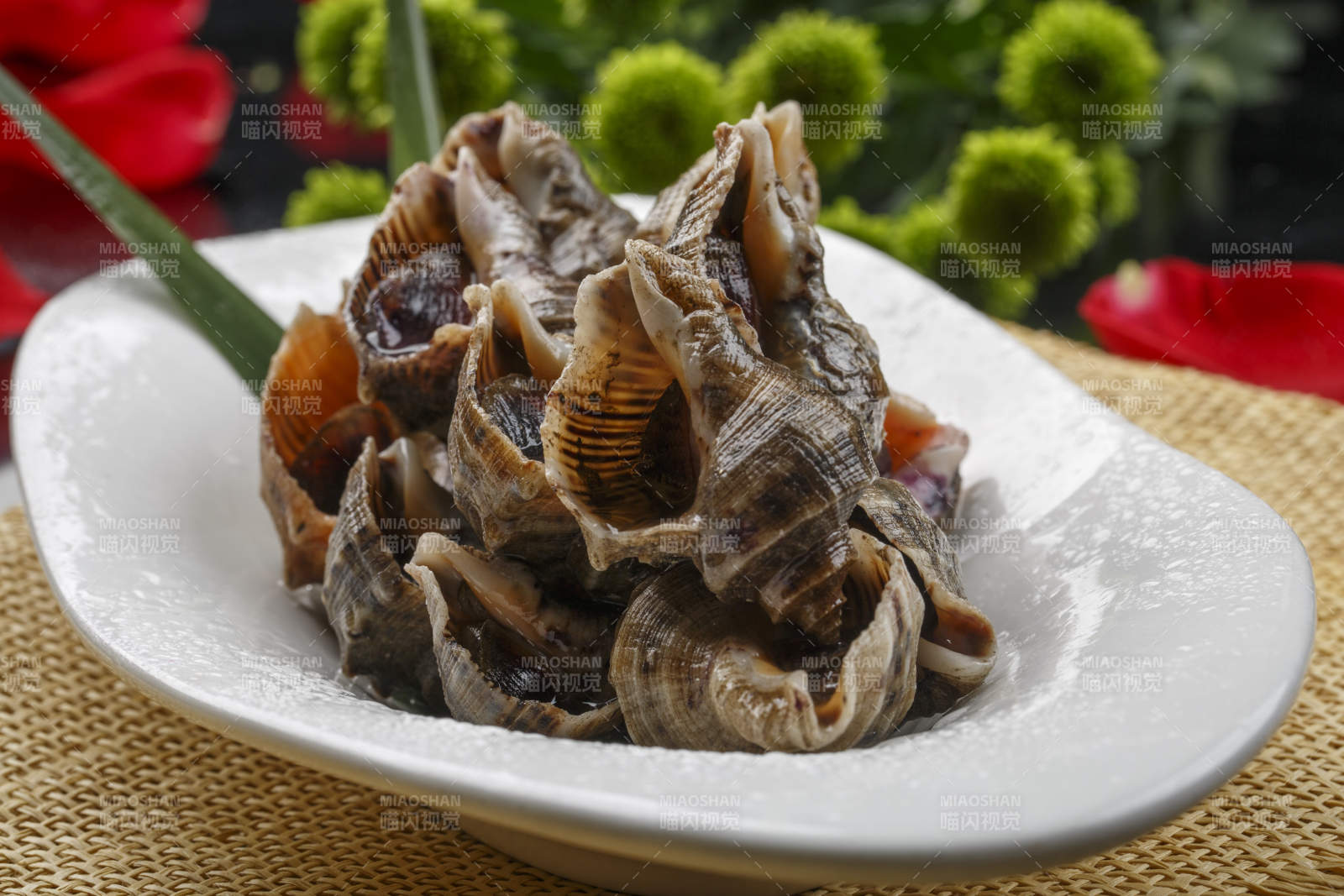 异形白瓷盘装的海鲜酱爆小海螺图片