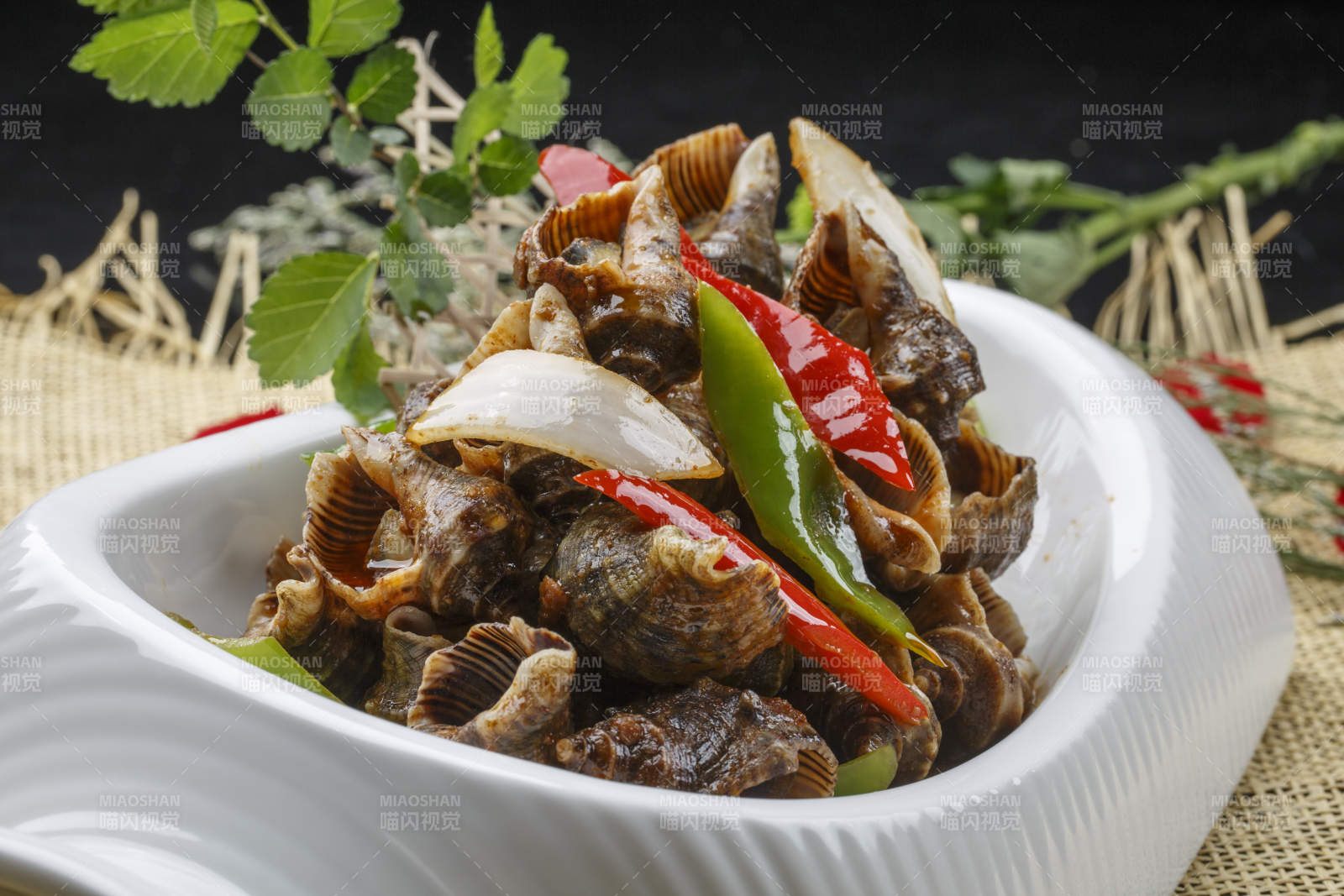 异形白瓷盘装的海鲜酱爆海螺图片