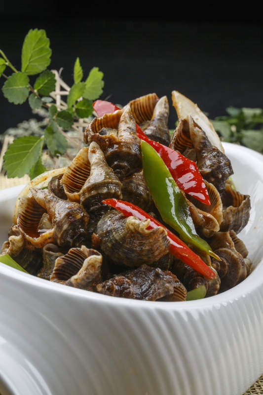 异形白瓷盘装的海鲜酱爆海螺图片