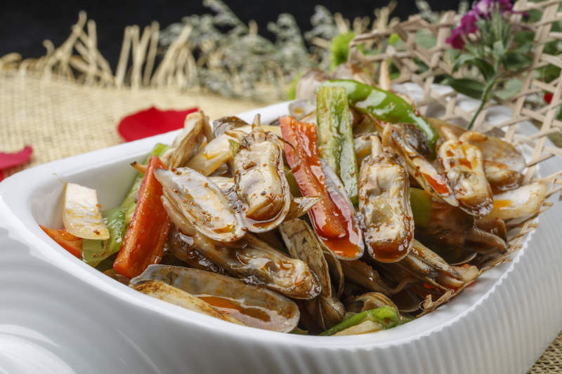 异形白瓷盘装的海鲜辣炒蛏子图片