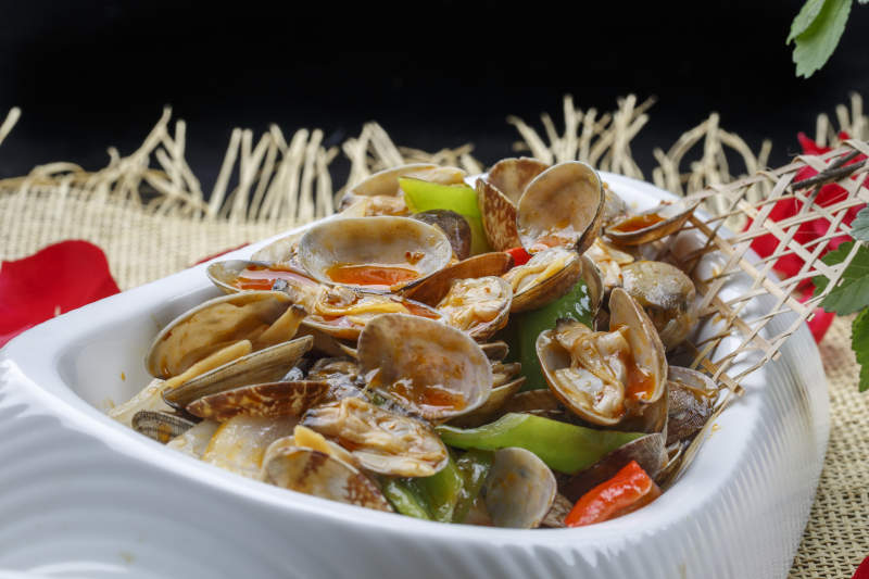 异形白瓷盘装的海鲜辣炒花蛤图片