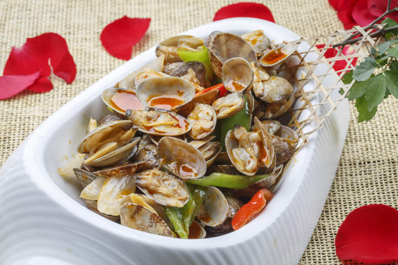 异形白瓷盘装的海鲜辣炒花蛤图片