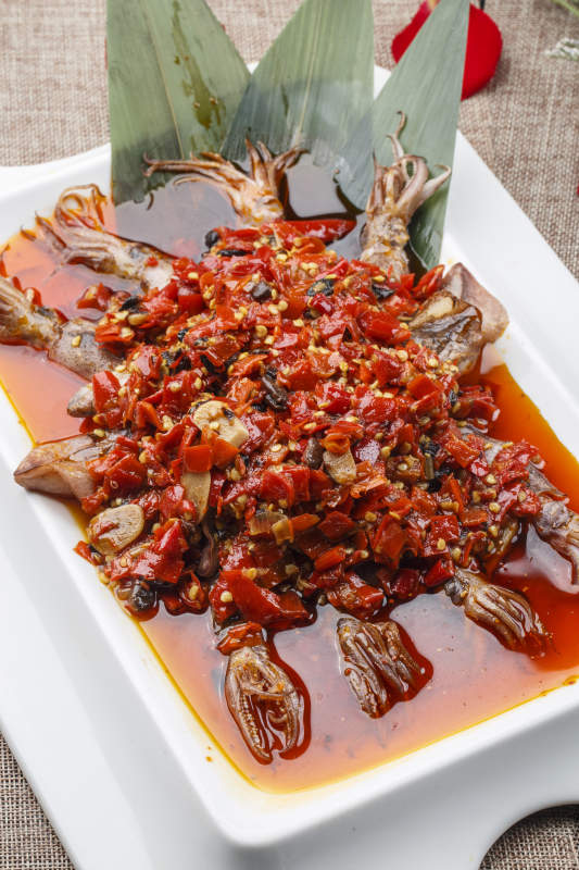 白色长方形瓷盘装的豆瓣酱香辣红油炒海鲜小管图片