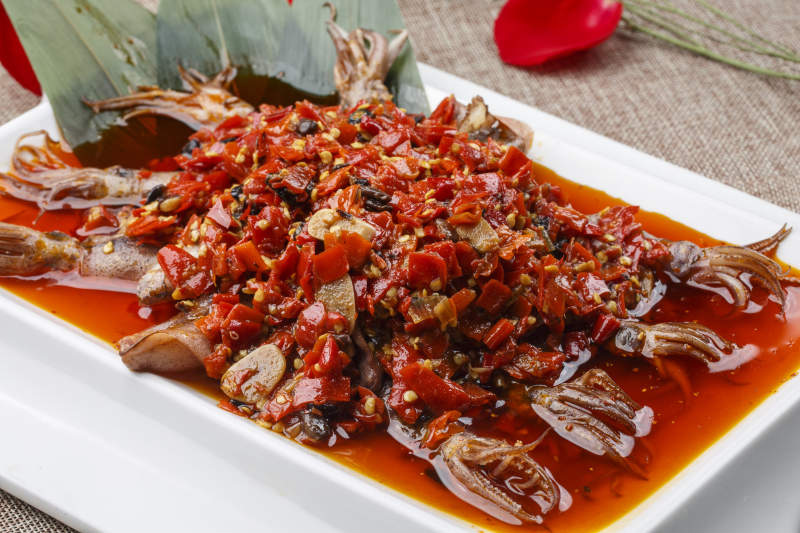 白色长方形瓷盘装的豆瓣酱香辣红油炒海鲜小管图片