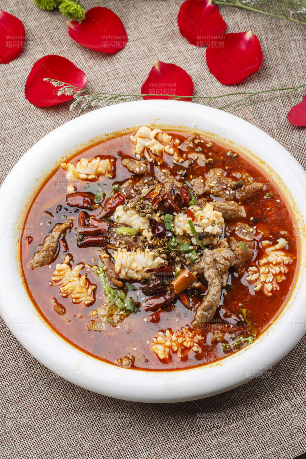 白色圆形瓷盘装的海鲜水煮肉海鲜毛血旺图片