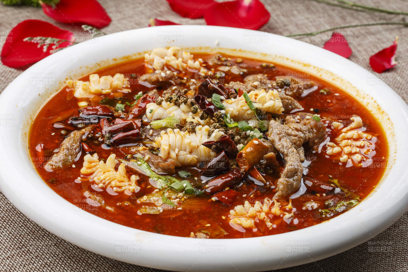 白色圆形瓷盘装的海鲜水煮肉海鲜毛血旺图片