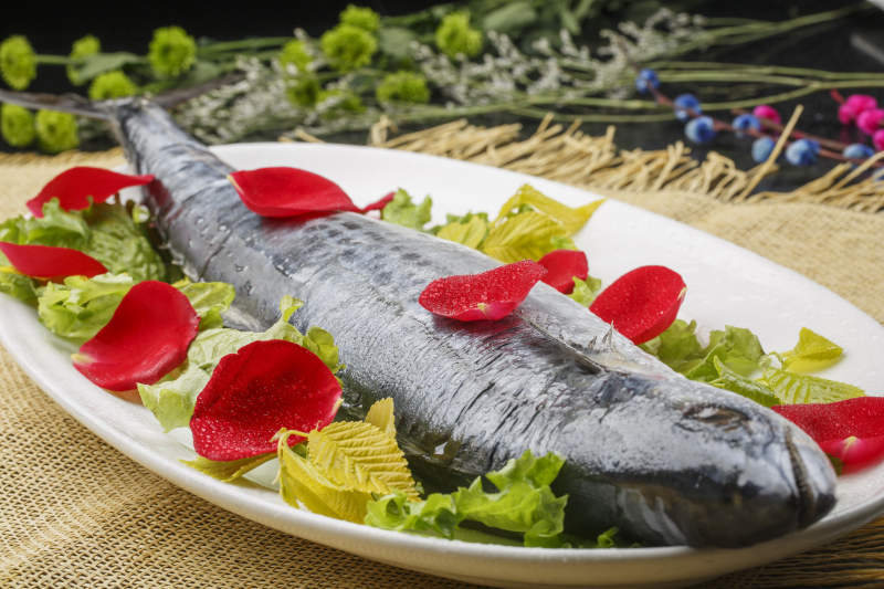 白色椭圆瓷盘装的新鲜马鲛鱼图片
